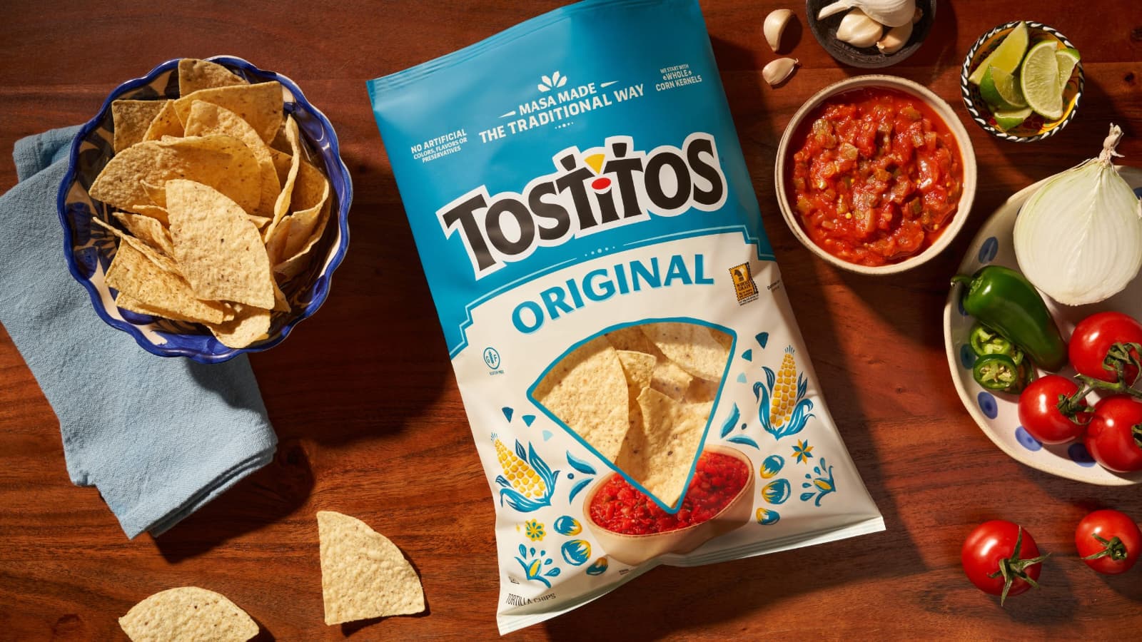 A bag of tortilla chips with salsa and fresh vegetables