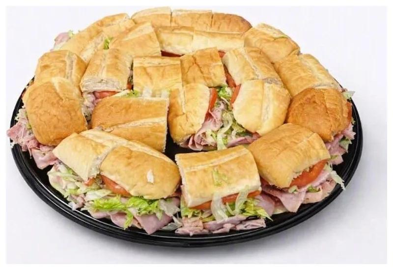 Sub Party Tray: cut subs with ham, tomato and lettuce on a round black tray