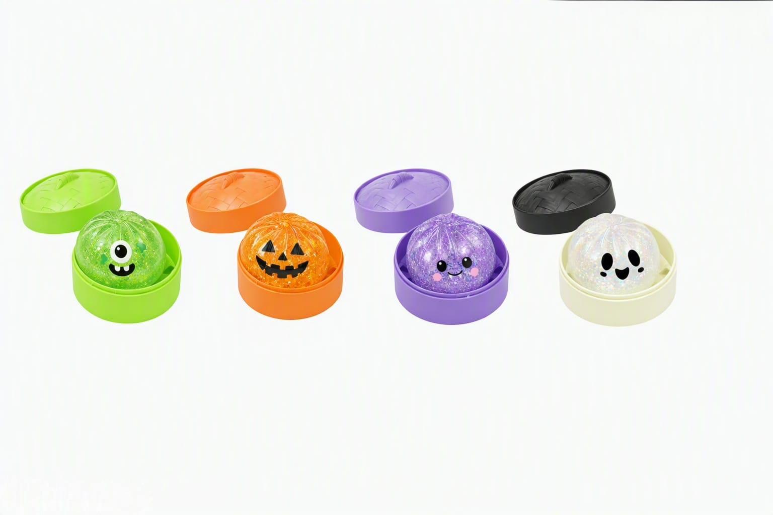 Four Halloween squish balls in little steamer baskets: a green monster, a pumpkin, a purple one and a ghost